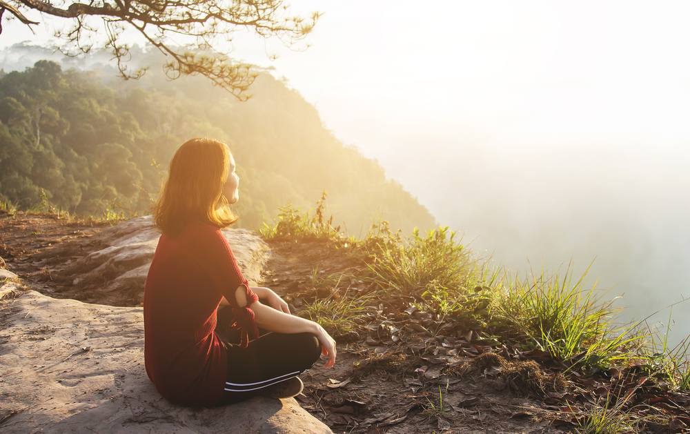 healthy,girl,relaxing,on,mountain,with,sunlight,flaring,in,tropical
