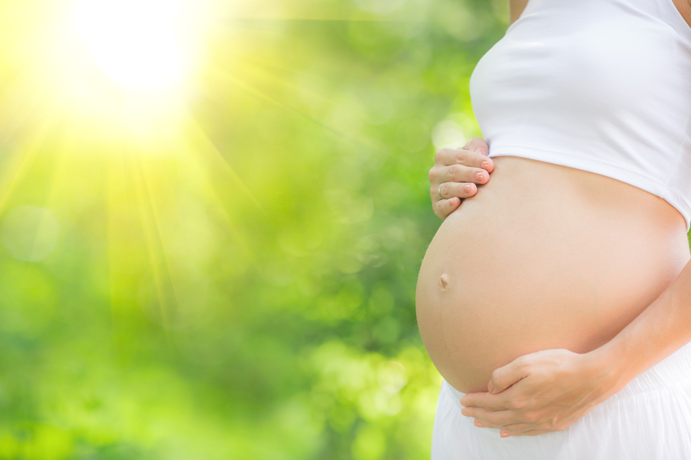 Beautiful,belly,of,young,pregnant,woman,against,green,spring,background beautiful,belly,of,young,pregnant,woman,against,green,spring,background